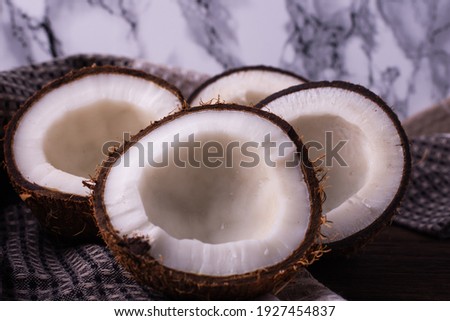 Coconut on a dark background. Coconut and coconut flakes scrambled side by side.