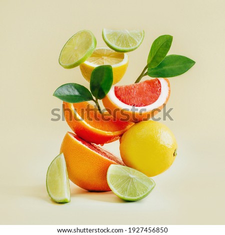 pyramid of citrus fruits grapefruit, orange, lemon, lime on yellow background Royalty-Free Stock Photo #1927456850