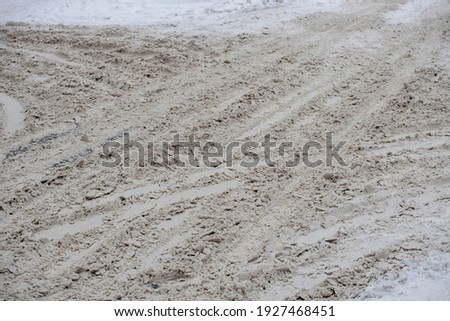 the road is covered with dirty snow traces from cars. High quality photo