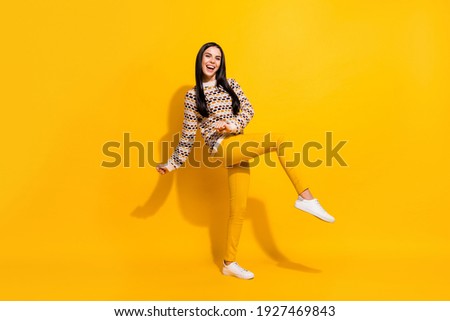 Full size photo of young attractive lovely happy excited girl dancing enjoying weekend isolated on yellow color background
