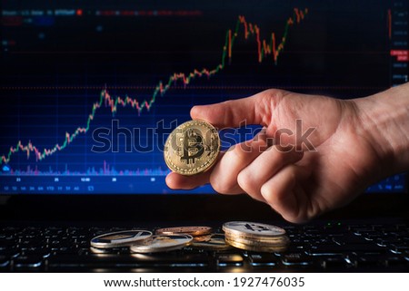 Business men holding golden bitcoin on computer trading chart background. Bitcoin as most important cryptocurrency concept Royalty-Free Stock Photo #1927476035
