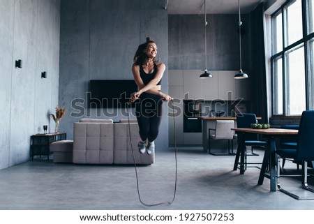 Sportsgirl with skipping rope at home. Royalty-Free Stock Photo #1927507253