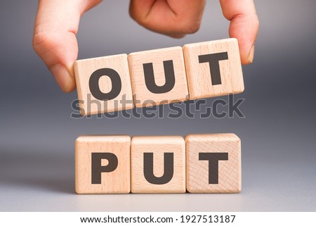 Closeup hand pull out some wood blocks from the stack with text : OUTPUT, output topic concept Royalty-Free Stock Photo #1927513187