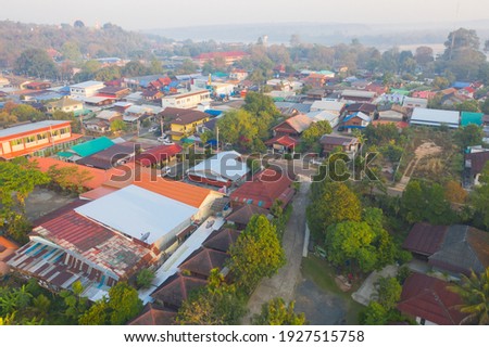 Aerial view of roofs of local village houses. Residential buildings in Ubon Ratchathani, Thailand. Urban city town in Asia. Architecture landscape background. Top view. Rural area.