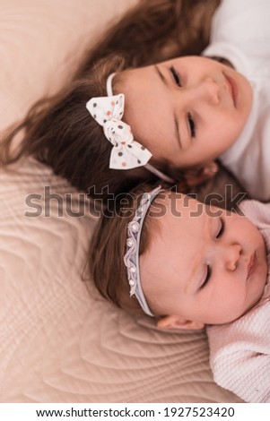 Head and shoulders portrait of young toddler girls wearing colorful headbands. Focus on the headband.