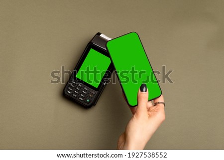 Close up photo of female hand paying with smartphone NFC