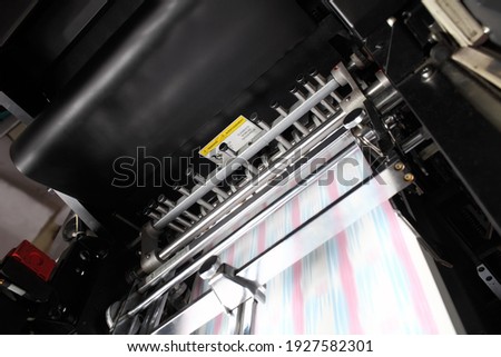 Printing press with blurry turning conveyor belt during work.