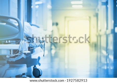 Mysterious, enchanting light in a hospital hallway with a bed in the foreground. Royalty-Free Stock Photo #1927582913