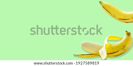 Peeling ripe banana on green background with space for text in banner size image