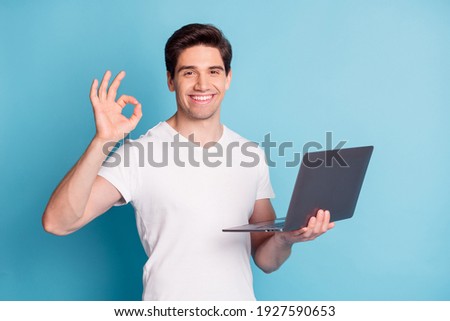 Photo of handsome person hand hold netbook show okey symbol isolated on pastel blue color background