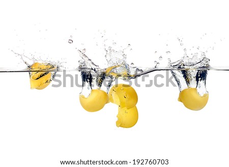 Lumaconi falling on water splashing. Durum wheat pasta. Cooking concept. Closeup image isolated on white background