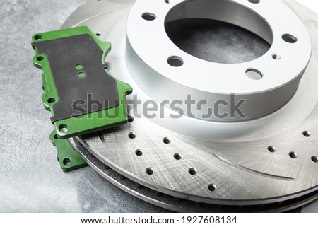 brake pad and Perforated brake discs on a dark gray table