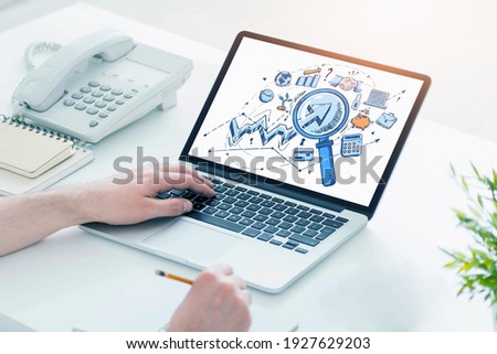 Hands and laptop display with set of icon and web network symbols. Concept of office work and web search with graph and diverse drawings