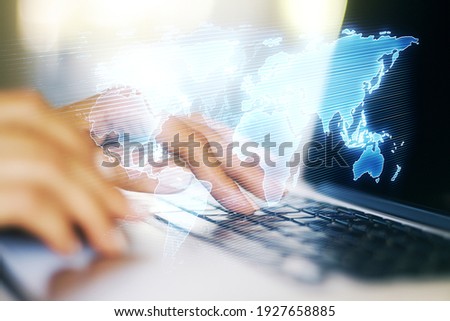 Abstract creative digital world map and hands typing on laptop on background, globalization concept. Multiexposure
