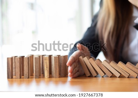  Businesswoman protect wooden block fall to planning and strategy in risk to business Alternative and prevent. Investment Insurance ,Business risk control concept, Royalty-Free Stock Photo #1927667378