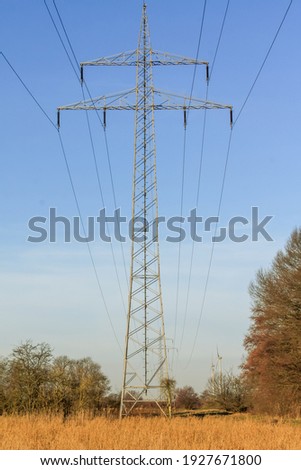 Cable line in a field with windmills in the background