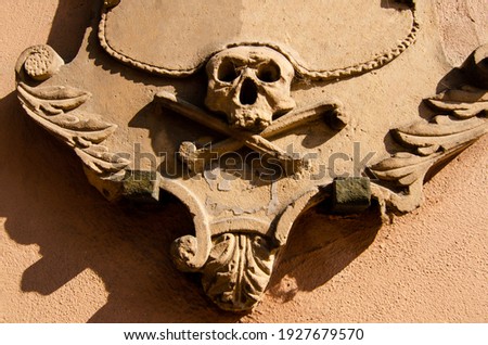Strasbourg, France, August 2019. A low relief with a skull on a street in the historic center.