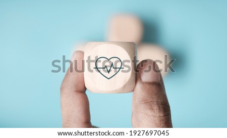 Hand hold wood cube icon healthcare medical on blue background, Health Insurance Concept Royalty-Free Stock Photo #1927697045