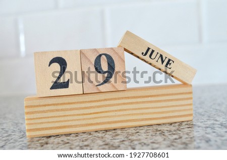 June 29, Cover design with number cube on a white background and granite table.