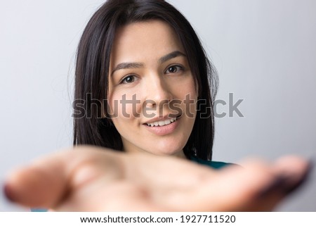 Portrait of attractive young woman wants to hug you, isolated on grey background.
