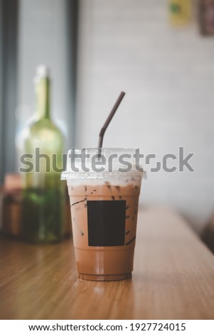Iced Mocha coffee in plastic cup put on wood bar in cafe