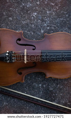 Front side of violin put on grunge surface background,blurry light around