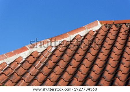 Replaced ridge tiles repairing previous storm and frost damage Royalty-Free Stock Photo #1927734368