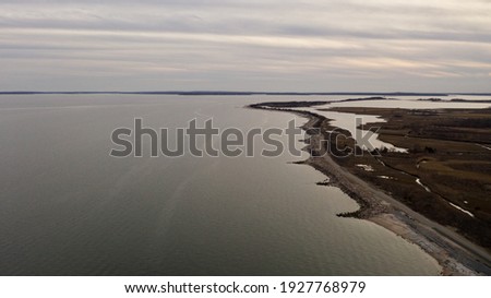 An aerial view of the eastern end of Orient Point on Long Island, New York. Taken during a golden sunset with cloudy skies. The waters were calm and the area was empty, quiet and peaceful.