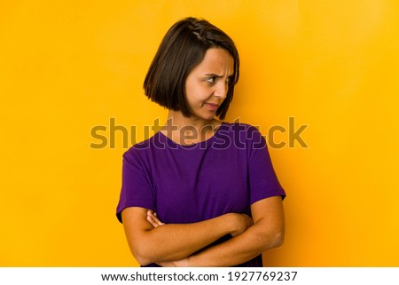 Young hispanic woman isolated on yellow dreaming of achieving goals and purposes