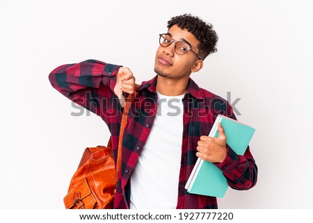 Young african american student curly man isolated holding books showing a dislike gesture, thumbs down. Disagreement concept.