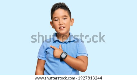Little boy hispanic kid wearing casual clothes cheerful with a smile on face pointing with hand and finger up to the side with happy and natural expression 