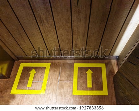 Yellow social distancing signs at elevator