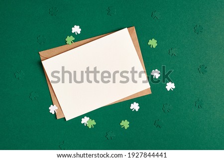 Saint Patricks day greeting card mockup with paper shamrock on green background, copy space