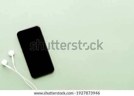 top view of smartphone with blank screen and headphones with copy space