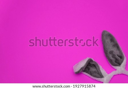 Happy Easter with gray bunny ears On bright pink Background. Minimal Easter concept. Flat lay. Copyspace for text. Easter banner, card. Humor Easter concept.                                       