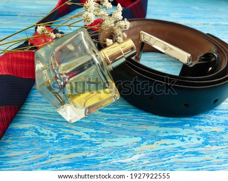 perfume bottle, tie belt on wooden background
