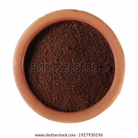 Powdered, instant coffee pile for espresso in clay pot isolated on white background, top view