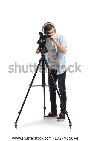 Young man recording with a camera on a tripod stand isolated on white background Royalty-Free Stock Photo #1927966844