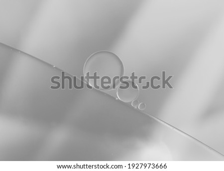 Abstract creative oil and water droplets on grey-silver colour background.