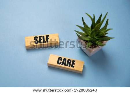 Self-care word on lightbox on blue background flat lay. Take care of yourself