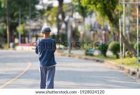 Back view of man wears blue linen clothes and hats to exercise at noon.