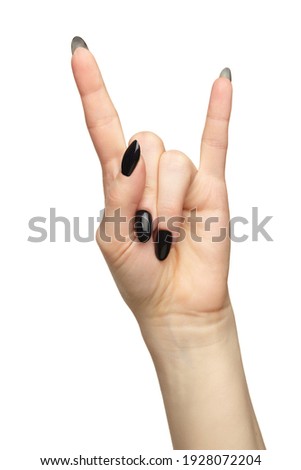 Female hand with black nails manicure.  Fingers in the shape of a victory sign. Isolated on white background. 