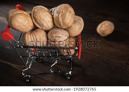 Walnuts in a metal trolley on a dark wooden background, close up, copy space