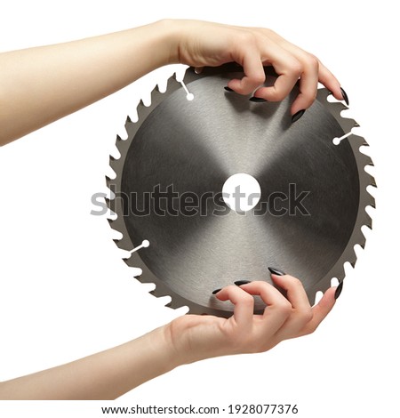 Female hands with black nails manicure with circular saw blade. Isolated on white background.