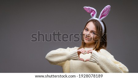 a girl in bunny ears on a gray background