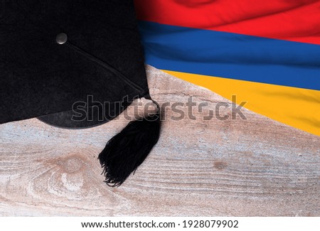 Black graduation hat on Armenia flag, education concept, top view