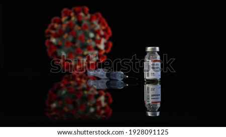 Coronavirus symbol and vaccine bottle syringe on black background