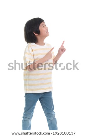 Cute Asian child pointing up with two hands on white background isolated