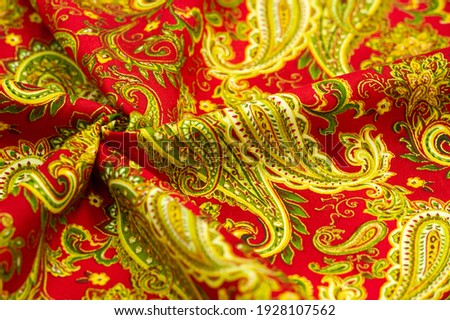 Paisley green pattern on a red background. decorated the bandanas of cowboys and bikers popularized by The Beatles, ushered in the era of hippies and became the emblem of rock and roll.