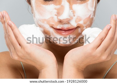 Woman putting foam on face. Royalty-Free Stock Photo #1928126000
